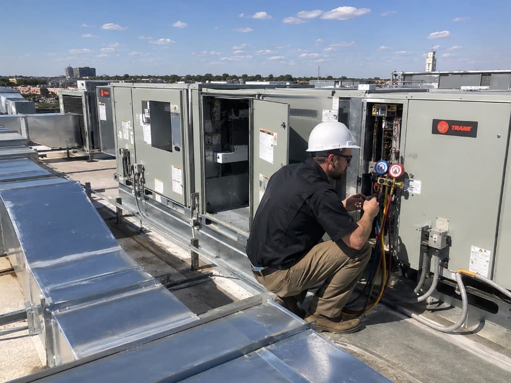 Commercial HVAC Services - Professional Texas Commercial Service Airnet HVAC technician inspecting commercial rooftop HVAC package unit equipment